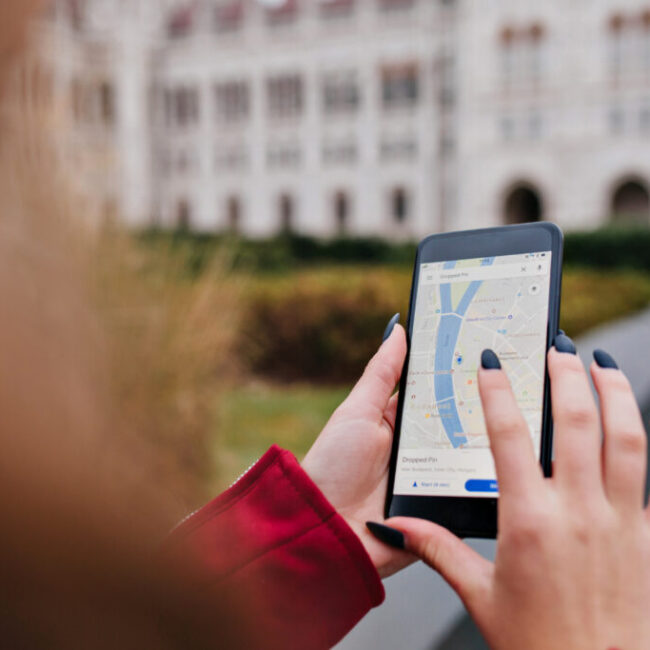 Woman with trendy manicure using gps for search right way. Photo of female hands with smartphone..